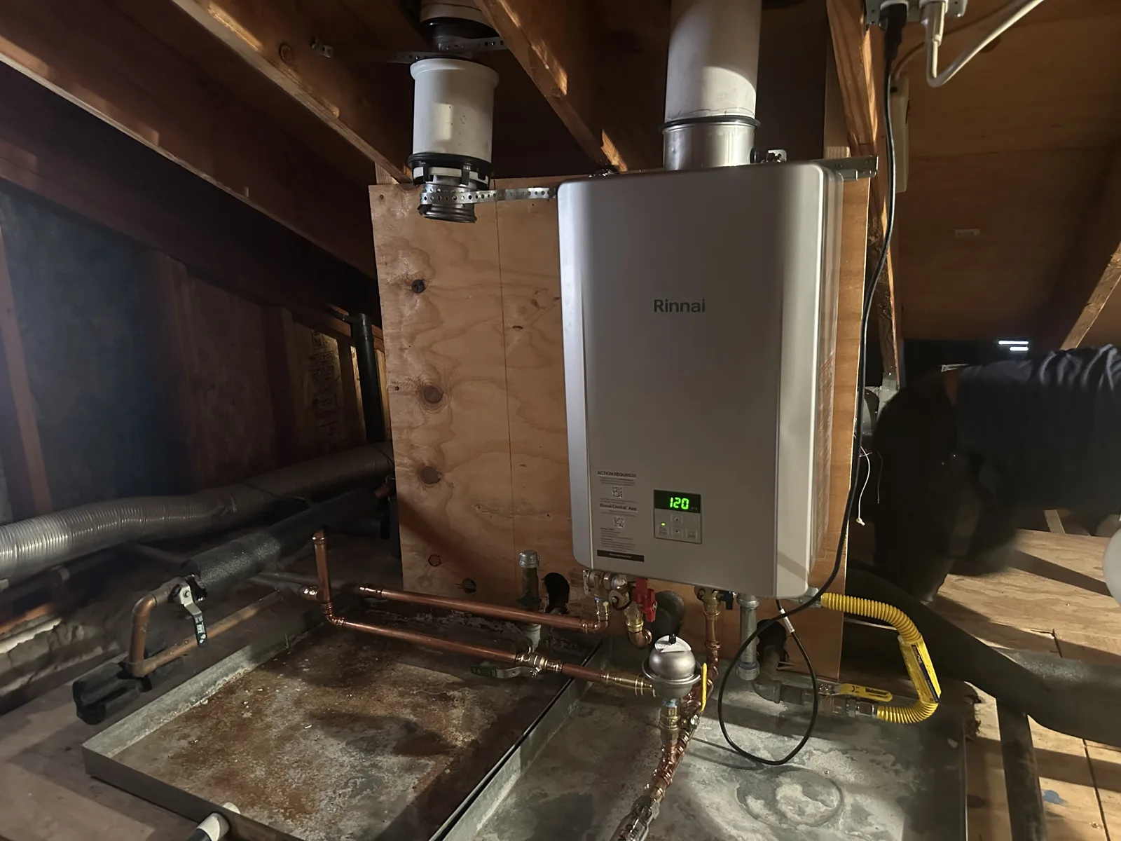 Tankless water heater installed in an attic space